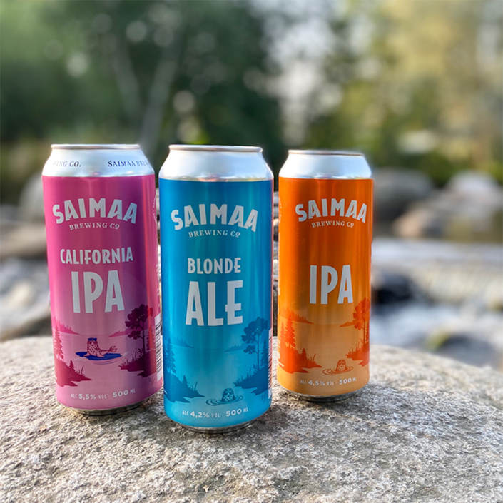 Kuvassa Saimaa Brewing Companyn uudistuneita oluttölkkipakkauksia kesäisen jokikuohun äärellä.